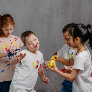 Children enjoying sensory finger painting activity during school holidays