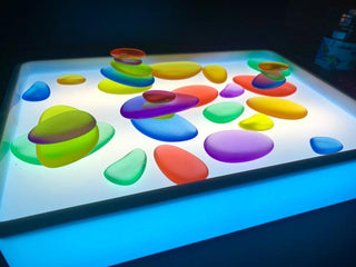 LED light board with colourful translucent pebbles for sensory play and early learning