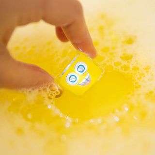 A yellow bath light cube in bath water 