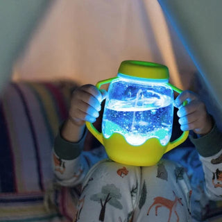 Child holding a glowing Glo Pals Sensory Jar, promoting focus and sensory stimulation with calming light effects for children with special needs.