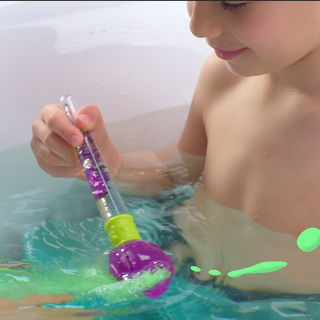 Child using the magic paintbrush with Zimpli Baff Bombz in a colorful, fizzing bath, creating a fun and interactive sensory play experience.