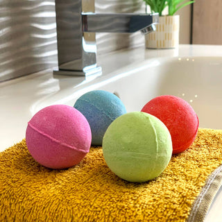 Four Zimpli Baff Bombz in assorted colours and scents – apple, strawberry, tutti frutti, and grape bath bombs for kids.